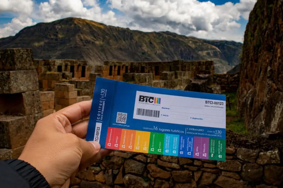 Boleto Turístico do Cusco (BTC) sendo mostrado em frente a um sítio arqueológico inca no Vale Sagrado