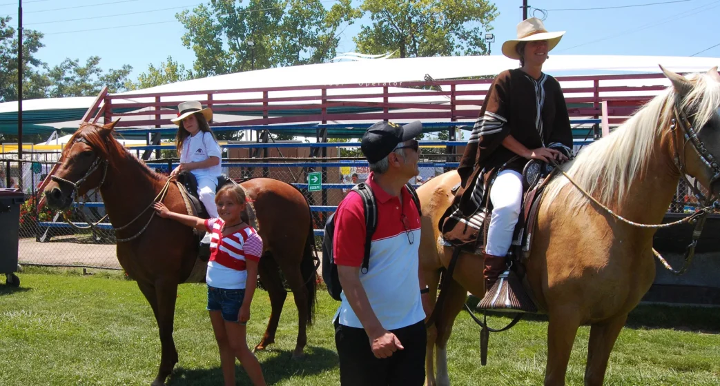 Família em um festival equestre com Cavalos Peruanos de Paso, com uma chalán montando e crianças posando para uma foto no gramado
