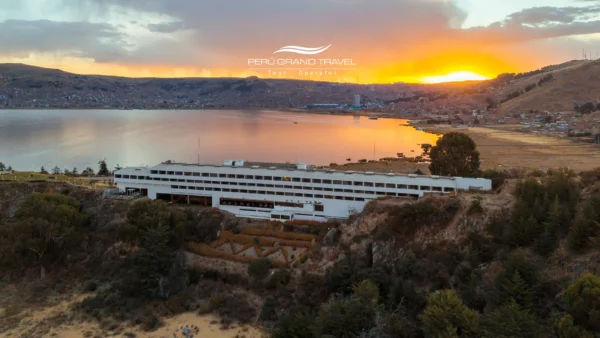 Hotéis de Luxo em Puno: vista panorâmica do pôr do sol de um hotel à beira do Lago Titicaca com a cidade de Puno ao fundo.