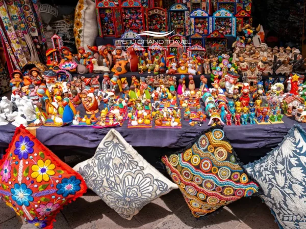 Onde comprar souvenirs no Peru Barraca colorida de artesanato peruano com figuras tradicionais, têxteis e souvenirs em mercado local