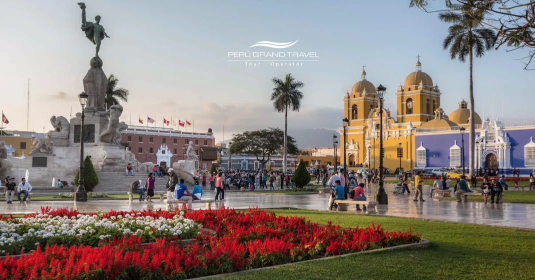 Plaza de Armas de Trujillo, Peru, com jardins, monumentos e a Catedral de Trujillo em tom amarelo, cercada por arquitetura colonial.