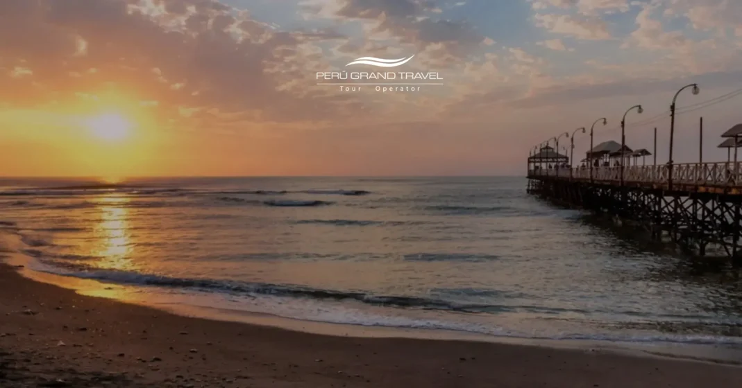 Pôr do sol sobre o oceano Pacífico em Trujillo, Peru, com ondas suaves e um píer de madeira avançando sobre o mar ao longo da costa norte.