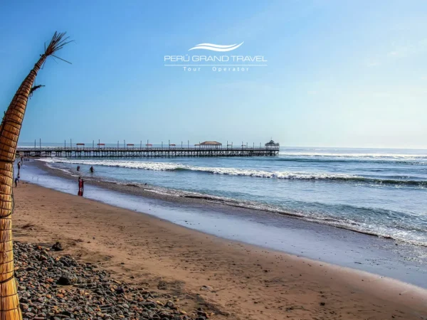 Praia de Huanchaco, perto de Trujillo, Peru, com os tradicionais caballitos de totora ao longo da costa arenosa do Pacífico