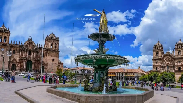 Tours de Meio Dia no Peru em Cusco, com a Plaza de Armas, a fonte histórica, a Catedral de Cusco e a arquitetura colonial sob um céu azul