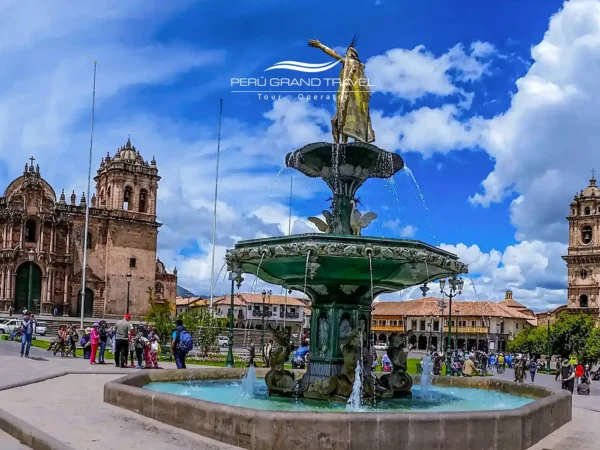 Tours de Meio Dia no Peru em Cusco, com a Plaza de Armas, a fonte histórica, a Catedral de Cusco e a arquitetura colonial sob um céu azul