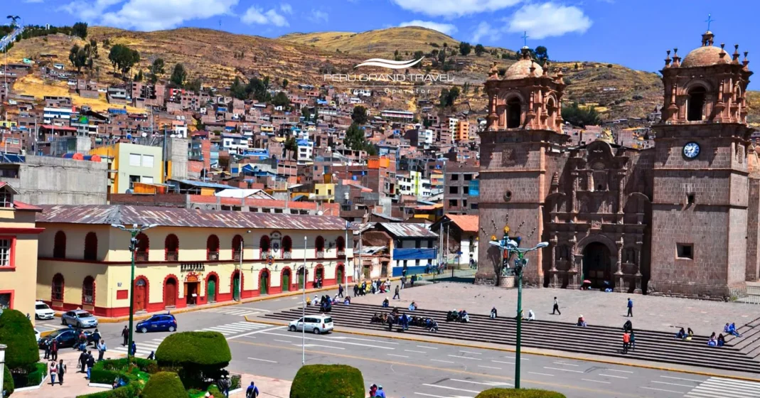 Vista aérea da Praça Principal de Puno, mostrando a Catedral Basílica, ruas da cidade e bairros coloridos nas encostas ao redor da praça