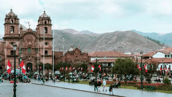 Plaza de Armas em Cusco, com muitas bandeiras peruanas e a vista da Igreja da Companhia de Jesus