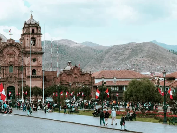 Plaza de Armas em Cusco, com muitas bandeiras peruanas e a vista da Igreja da Companhia de Jesus
