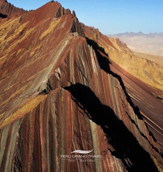 Vista aérea de Pallay Punchu, uma das montanhas arco-íris do Peru, com formações geológicas únicas.