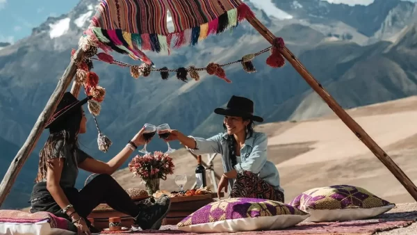 Mulheres brindando em um piquenique com lhamas no Vale Sagrado dos Incas, Cusco