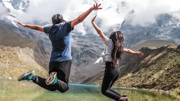 Turistas pulando na lagoa Humantay em Cusco, vista da lagoa turquesa e das montanhas