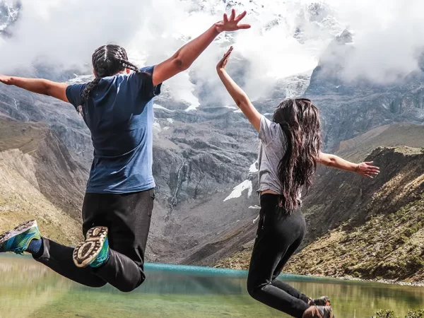 Turistas pulando na lagoa Humantay em Cusco, vista da lagoa turquesa e das montanhas